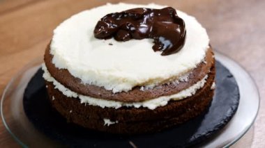 Kek üzerine krema çikolata ganache. Bisküvi pasta ev yapımı tatlı dekorasyon kapatın. Dekorasyon ve pasta şekillendirme kadın baker.