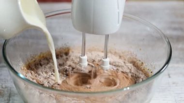 İnsan eli kapta şeker tatlı meyilli için kek yapma ile karıştırılmış yumurta süt ve un ekleme.