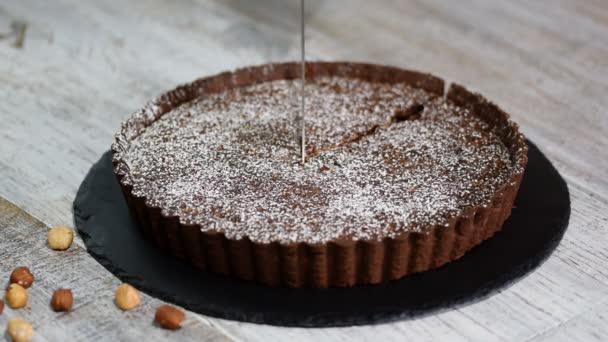 Corte casero tarta de chocolate negro sobre fondo rústico . — Vídeo de stock