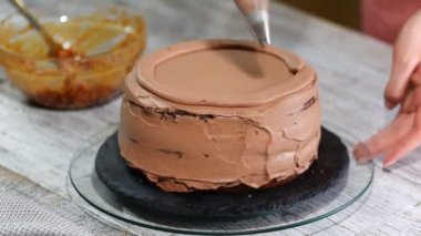 Karamel fıstık kek üzerine doldurma el koyar. Pasta krema ve fındık ile.