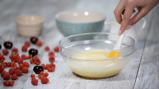 Young cook stirs cream in bowl. — Stock Video