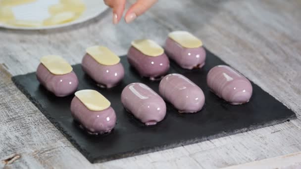Preparando sobremesas modernas, francesas - mousse com esmalte de espelho roxo. Decorar bolos de mousse francês — Vídeo de Stock