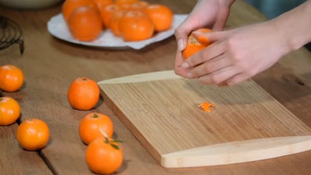 Handen van de vrouw Peel Tangerine, Mandarijn op houten achtergrond. — Stockvideo