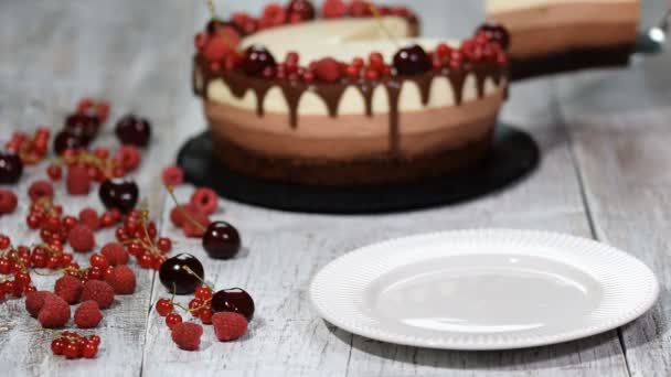 Sepotong lezat tiga coklat mousse kue dihiasi dengan berry segar . — Stok Video