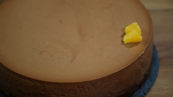 Womens hand ingericht chocolademousse taart met oranje segmenten. — Stockvideo