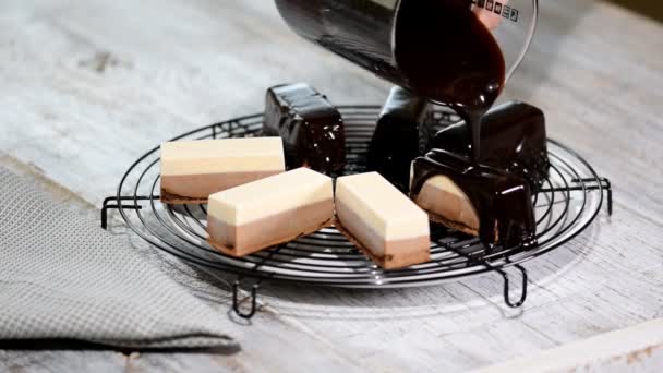 Giet de chocolade mirror glaze op een heerlijke mousse dessert. Vloeibare smakelijke zoete dessert koken. — Stockvideo