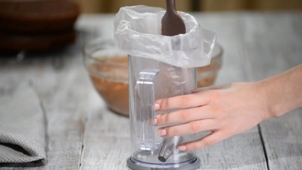 Шеф-кухар кладе шоколадний крем у кондитерський мішок . — стокове відео