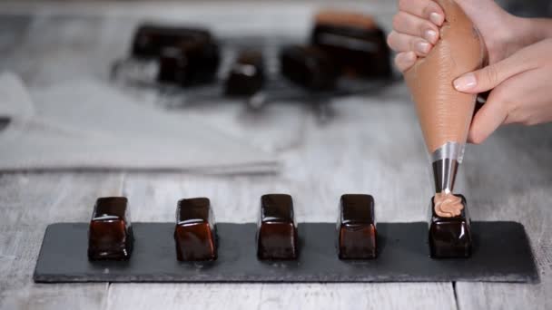 Squeezing the cream on the cakes. Delicious yummy cream squeezed on the cakes. Making modern french dessert. — Stock Video