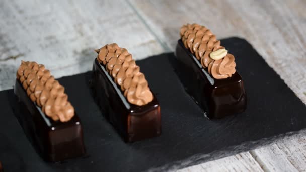 Prăjitură cu spumă franceză, vedere de sus. Torturi acoperite cu glazură de ciocolată pe fundal din lemn. Desert cu aroma delicata . — Videoclip de stoc