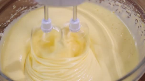Roztrzepane jajka z trzepaczek miksera w misce. — Wideo stockowe