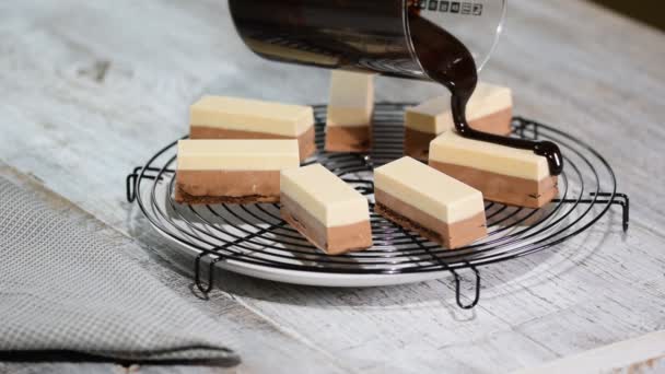 Das Schokoladen-Sahnehäubchen auf dem gefrosteten Kuchen. Moderner französischer Moussekuchen mit Schokoladenspiegelglasur. — Stockvideo