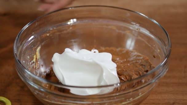 Bateu claras de ovo em massa de chocolate. Mexendo claras de ovo e massa de bolo com chocolate — Vídeo de Stock