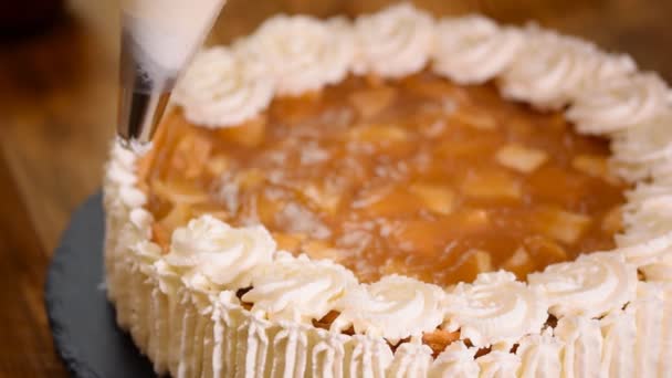 Σεφ ζαχαροπλαστικής διακοσμεί ένα κέικ της apple σε ένα κατάστημα καραμελών. — Αρχείο Βίντεο