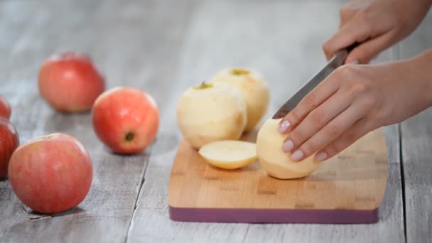 La chica está cortando manzana en la tabla de cortar . — Vídeos de Stock