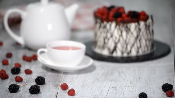 Trendy rustieke verticale roll hoge taart met chocolade, vanille crème en bessen. — Stockvideo