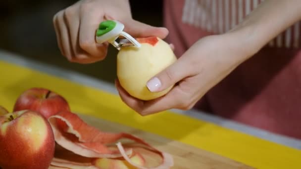 Yemek elma bir ahşap tahta üzerinde peeling eller. — Stok video