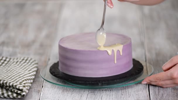 Προετοιμασία ενός κέικ διακοπών. Το κορίτσι ρίχνει υγρή λευκή σοκολάτα. — Αρχείο Βίντεο