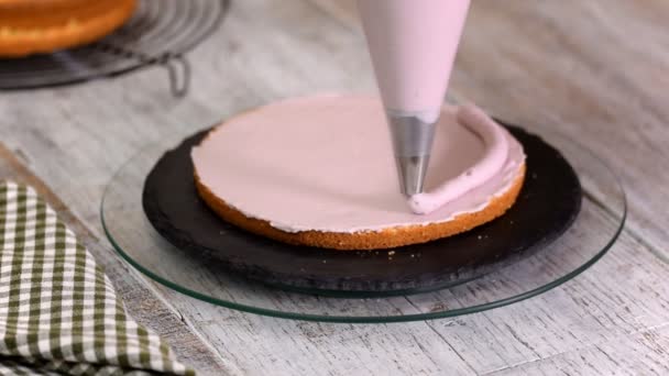De dames handen knijpen de crème op een taart. Lekkere crème op de taart. — Stockvideo