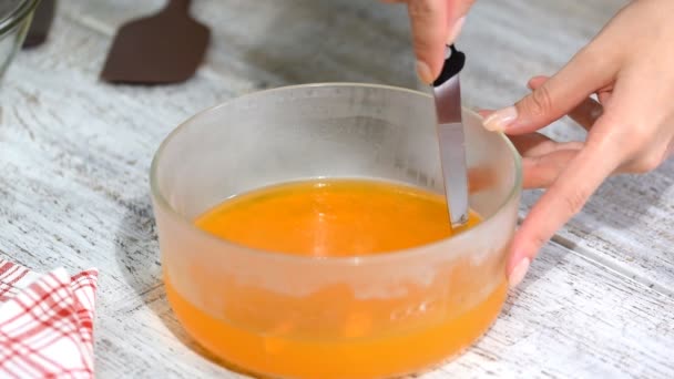 Жіночі руки розрізають апельсинове желе на шматки . — стокове відео