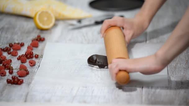 Rullande choklad degen på lagret av bakning pergament. Att göra choklad layer cake. — Stockvideo