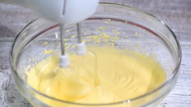 Beating eggs with electric mixer in glass bowl. — Stock Video