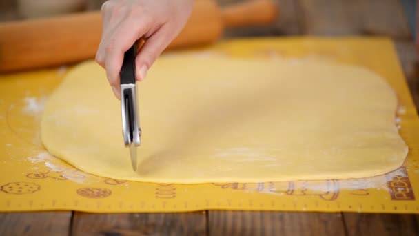 Mujer cortando masa cruda con un cuchillo de pizza . — Vídeo de stock