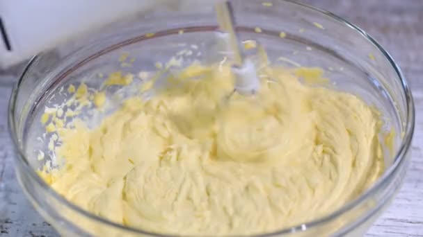 Mixing white cream in bowl with mixer. Electric mixer whipping cream in mixing bowl. Sweet food preparation. Making cream dessert. close up. isolated. black bacground — Stock Video