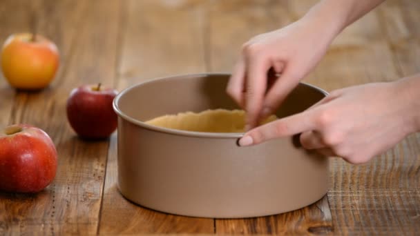 Uma mulher a fazer bolo de maçã na cozinha. Um bolo de maçãs frescas . — Vídeo de Stock