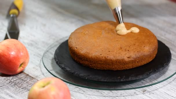 Pasticciere con sacchetto di pasticceria che spreme la crema su torta a cucina. Il concetto di pasticceria fatta in casa, torte di cottura. — Video Stock