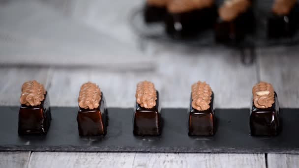 Bolos de mousse francês com esmalte de chocolate no prato. Bolo europeu moderno pastelaria . — Vídeo de Stock