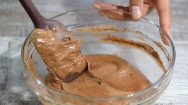 Mixing batter on kitchen. Adding melted butter to the chocolate batter.