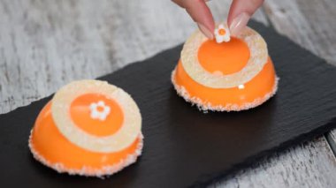 Portakal aynası sır kaplama ile mango ve Hindistan cevizi Mousse tatlı. Arka planda modern Avrupa pastası. Turuncu sır ile kaplı Fransız Mousse kek.