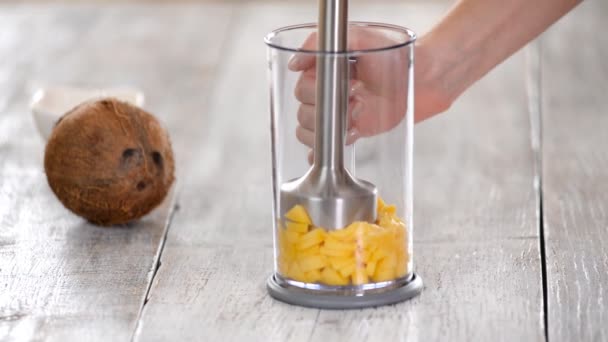 Woman grinds mango with a blender. Making mango puree. — Stock Video