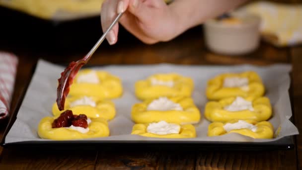 Сырое сладкое дрожжевое тесто на листе выпечки, наполняющее булочки вишней . — стоковое видео