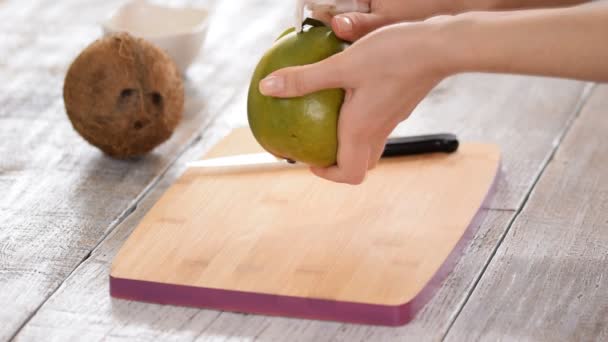 Manos pelando mango sobre tabla de cortar . — Vídeos de Stock