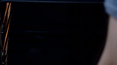 Evde yemek pişirmek, fırında pişirmek. Mutfağındaki kız fırına kurabiye koyuyor..