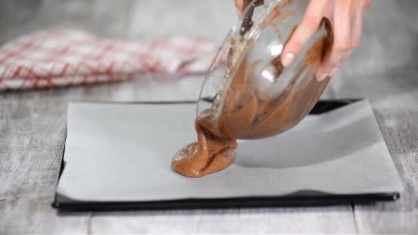 Verter la masa de pastel en la bandeja para hornear. Hacer pastel de capa de chocolate . — Vídeo de stock