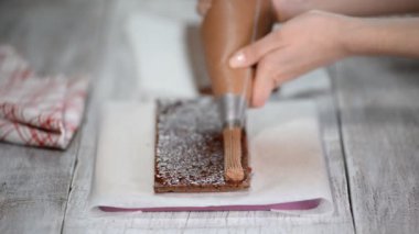 Bir pasta pişirme. Kek üzerine krema sıkma. Kek üzerine sıkılmış lezzetli lezzetli krem.