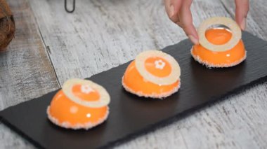 Portakal aynası sır kaplama ile mango ve Hindistan cevizi Mousse tatlı. Arka planda modern Avrupa pastası. Turuncu sır ile kaplı Fransız Mousse kek.