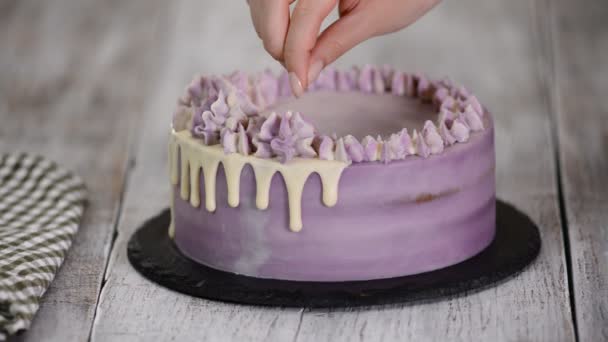Jovem mulher decorando delicioso bolo na cozinha — Vídeo de Stock