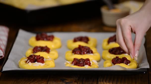 Chef saupoudrer flocons d'amandes sur les petits pains cerises crus — Video