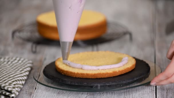 De dames handen knijpen de crème op een taart. Lekkere crème op de taart. — Stockvideo