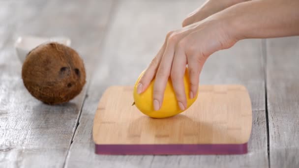 女性シェフは、木製のまな板にマンゴーを切断手. — ストック動画