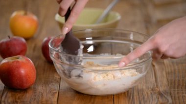 Pişirme için hamur hazırlanıyor. Spatula ile karıştırma kabında Tatlı meyilli. Elmalı kek yapma