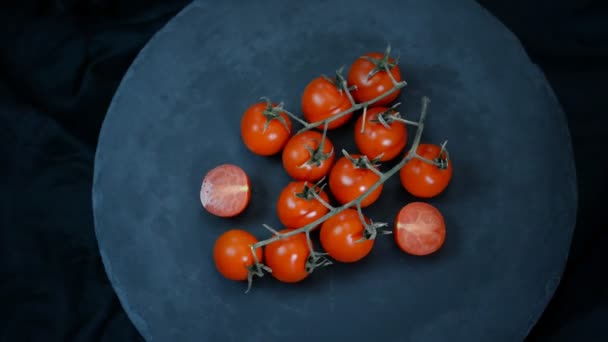 Tomates cerises rouges tournantes sur fond noir. Vue du dessus . — Video