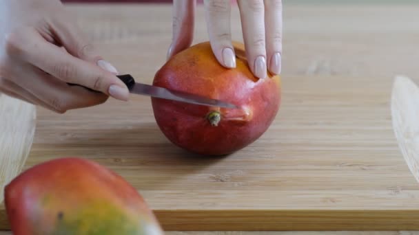 Женщины-повара руки ломтик манго на деревянной доске резки . — стоковое видео