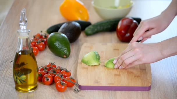 Vrouwelijke handen snijden avocado voor sandwich. — Stockvideo