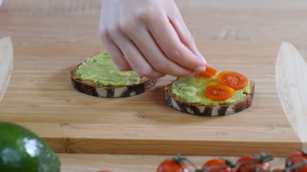 Cooking bruschetta with avocado, cherry tomatoes and prosciutto cotto — Stock Video