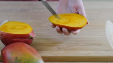 Kadın Şefler ahşap kesme tahtası üzerinde dilim mango eller.