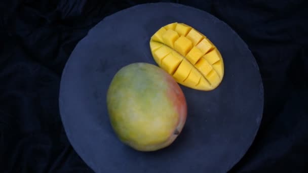 Organiska tropiska frukter, närbild glider Mango på svart plåt. — Stockvideo